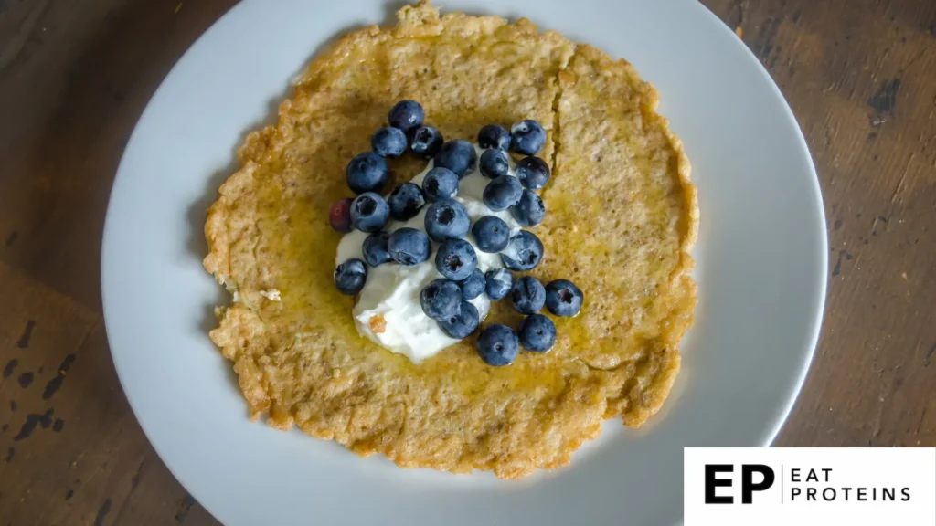 A table set with a plate of Dukan Oat Bran Galette decorated with blueberry