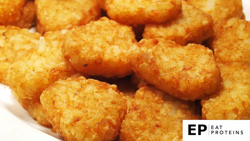 The image shows a close-up view of a plate filled with golden-brown hash browns. The hash browns have a crispy, crunchy texture with an even, appetizing golden hue, and a lightly seasoned appearance