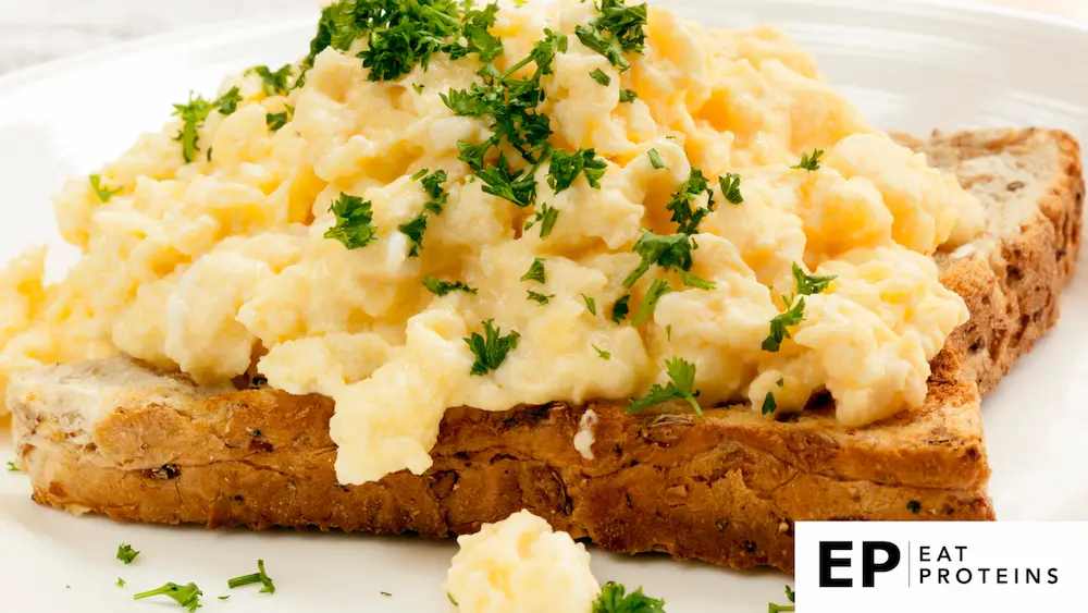 A scrambled eggs on piece of bread sprinkle with chop green