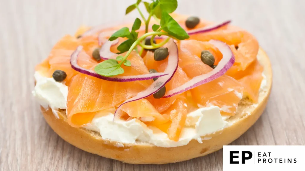 A plate with smoked salmon and dill on whole-grain bread, surrounded by Mediterranean-inspired breakfast items