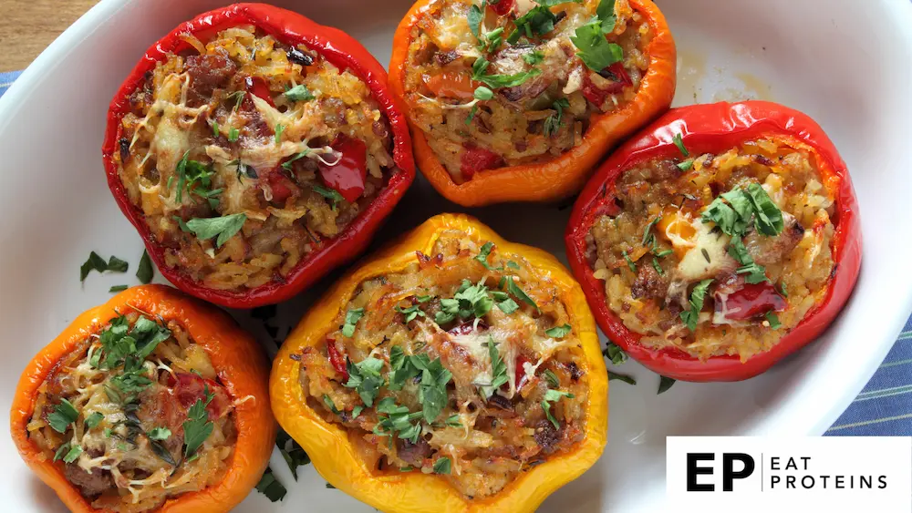 A colorful array of bell peppers stuffed with rice and other whole foods, arranged on a plate