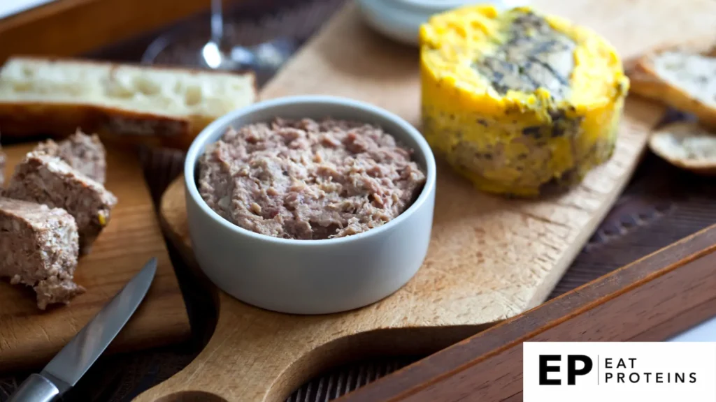 A wooden board with a small bowl of sunflower seed pâté, accompanied by sliced bread and a yellow block of plant-based pâté, garnished with herbs. The Eat Proteins (EP) logo is visible in the bottom right corner