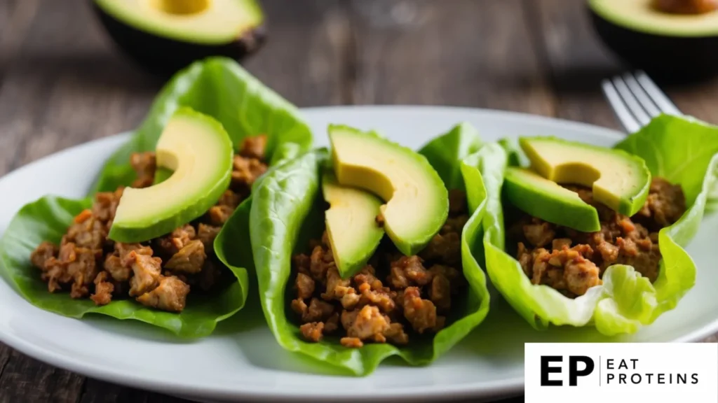 Fresh green lettuce leaves filled with cooked turkey and creamy avocado, arranged on a clean white plate