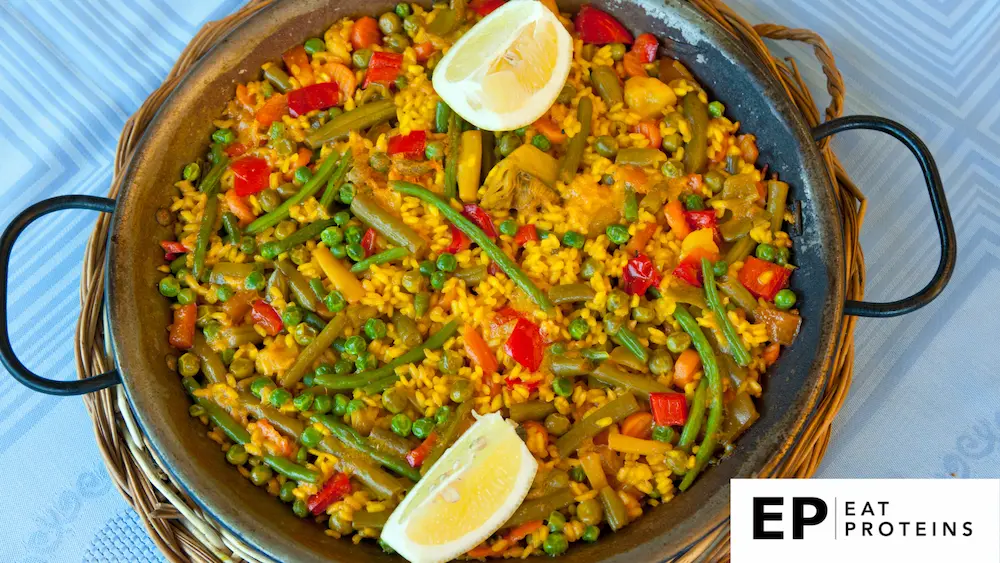 A colorful array of vegetables, rice, and herbs sizzling in a large pan, emitting a mouthwatering aroma