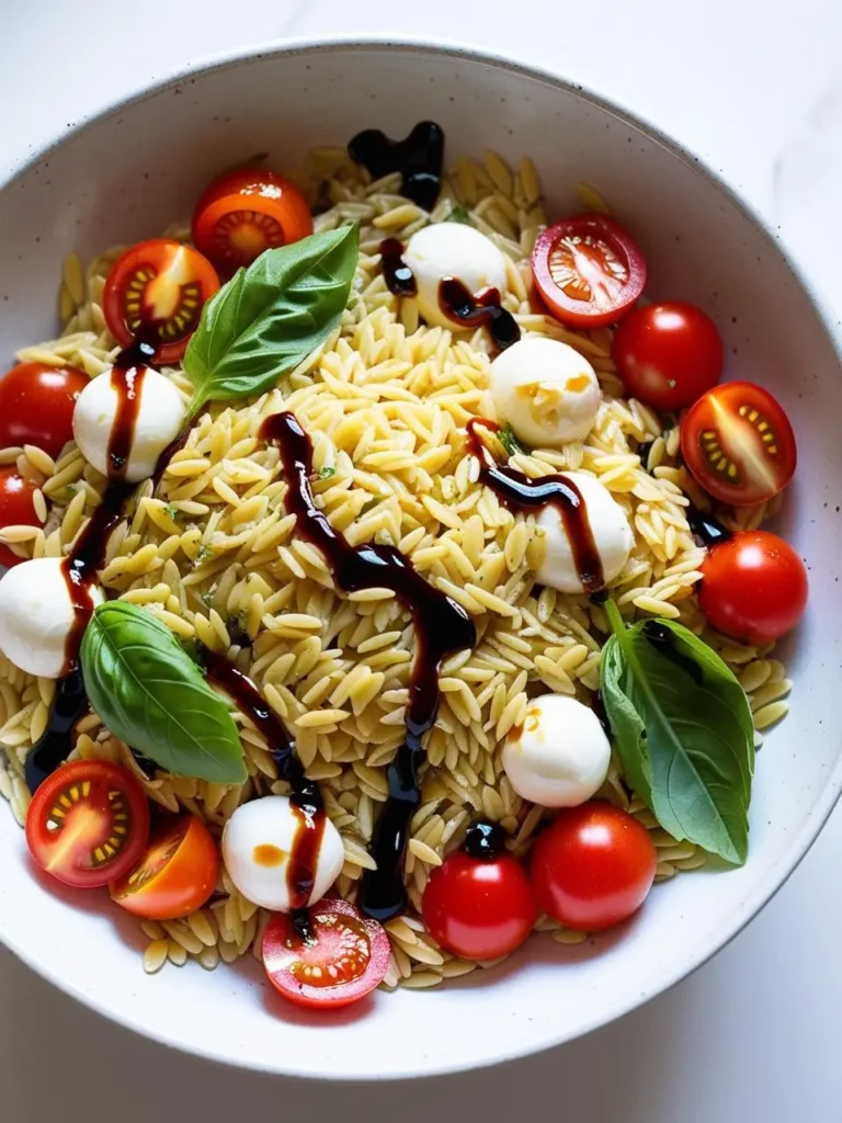 A vibrant and refreshing orzo salad with cherry tomatoes, mozzarella pearls, and fresh basil. The salad is drizzled with balsamic glaze, adding a touch of sweetness and tanginess. It's a perfect light and flavorful summer dish.