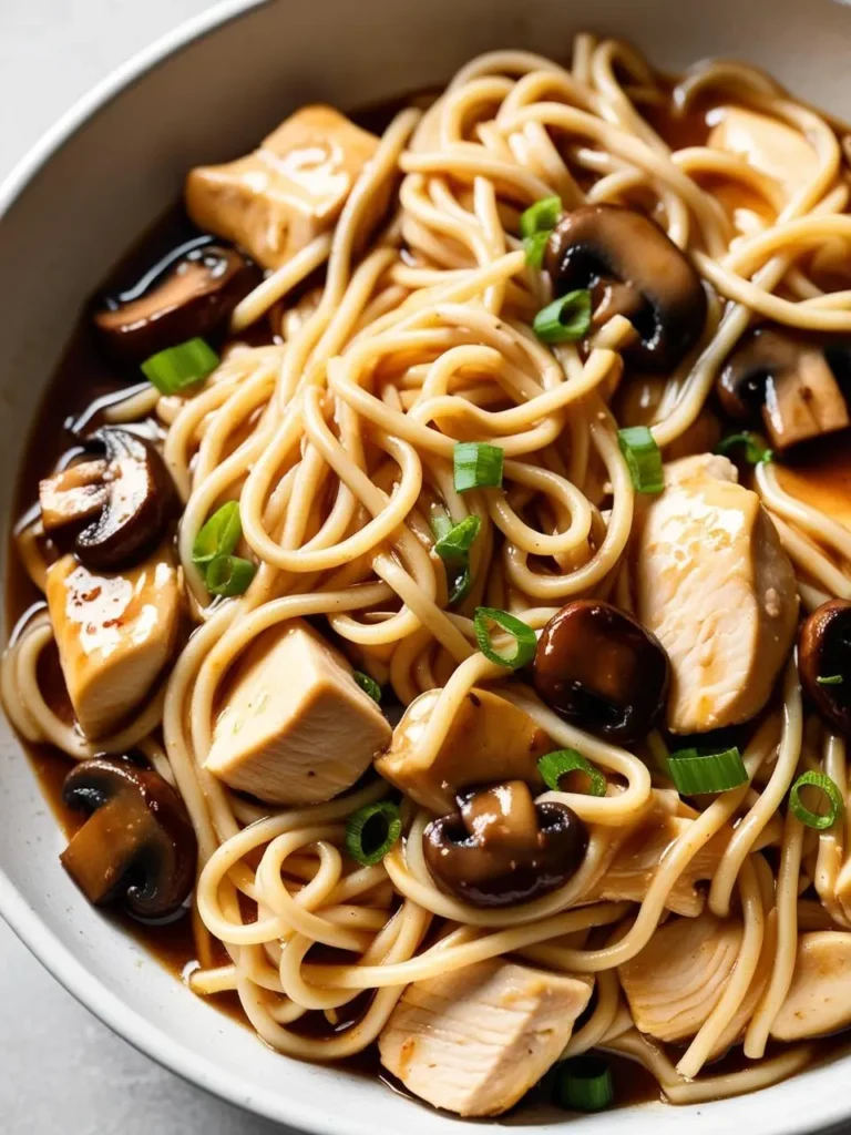 A close-up image of a bowl of Chinese Braised Mushroom Noodles. The noodles are topped with tender chicken, savory mushrooms, and a rich, flavorful sauce. Green onions garnish the dish, adding a touch of freshness.