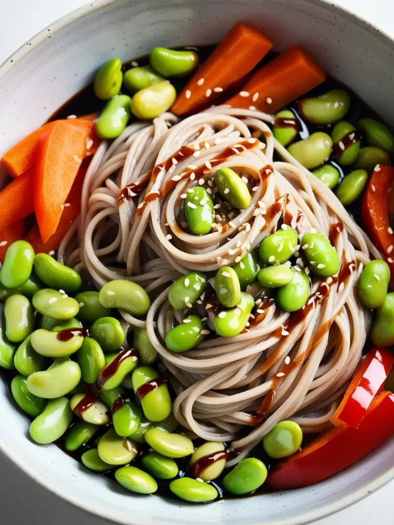 A bowl of soba noodles topped with edamame, carrots, and bell peppers. The noodles are drizzled with a sesame dressing, making the dish look colorful and appetizing.