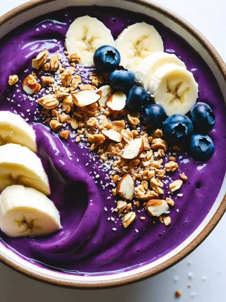 A slice of creamy cheesecake topped with a generous layer of fresh blueberries. The cheesecake has a golden crust and is dusted with powdered sugar. The plate is also decorated with scattered blueberries, making it look like a delicious and decadent dessert.